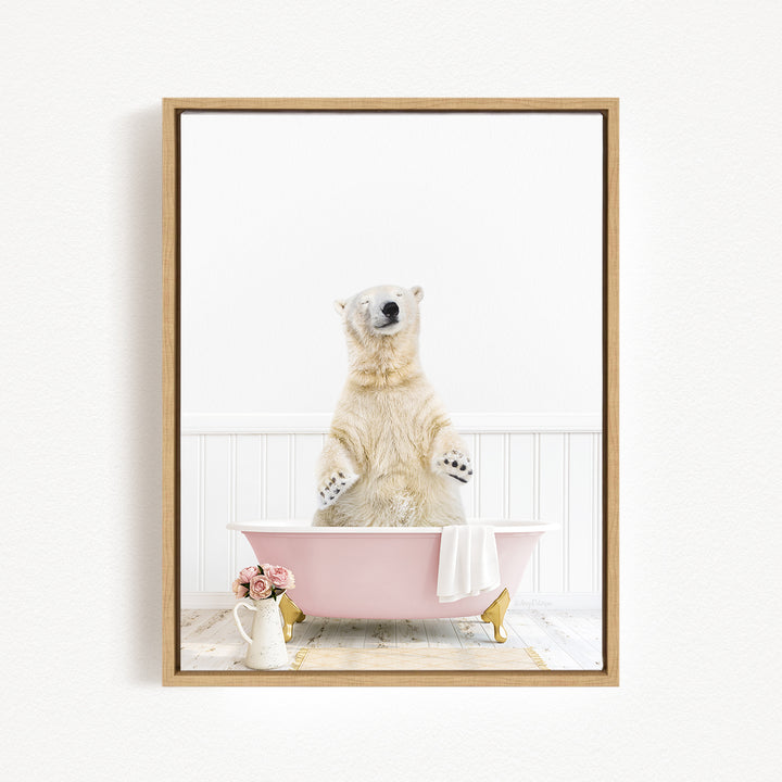 A polar bear standing in a pink bathtub, with a vase of flowers and a towel nearby.