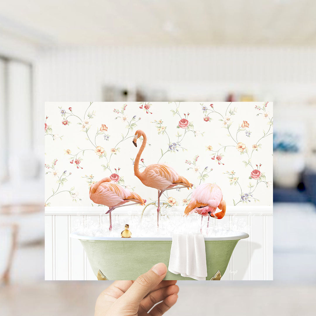 A hand holds up a collage of three images featuring pink flamingos in a bathtub, with a floral wallpaper backdrop.
