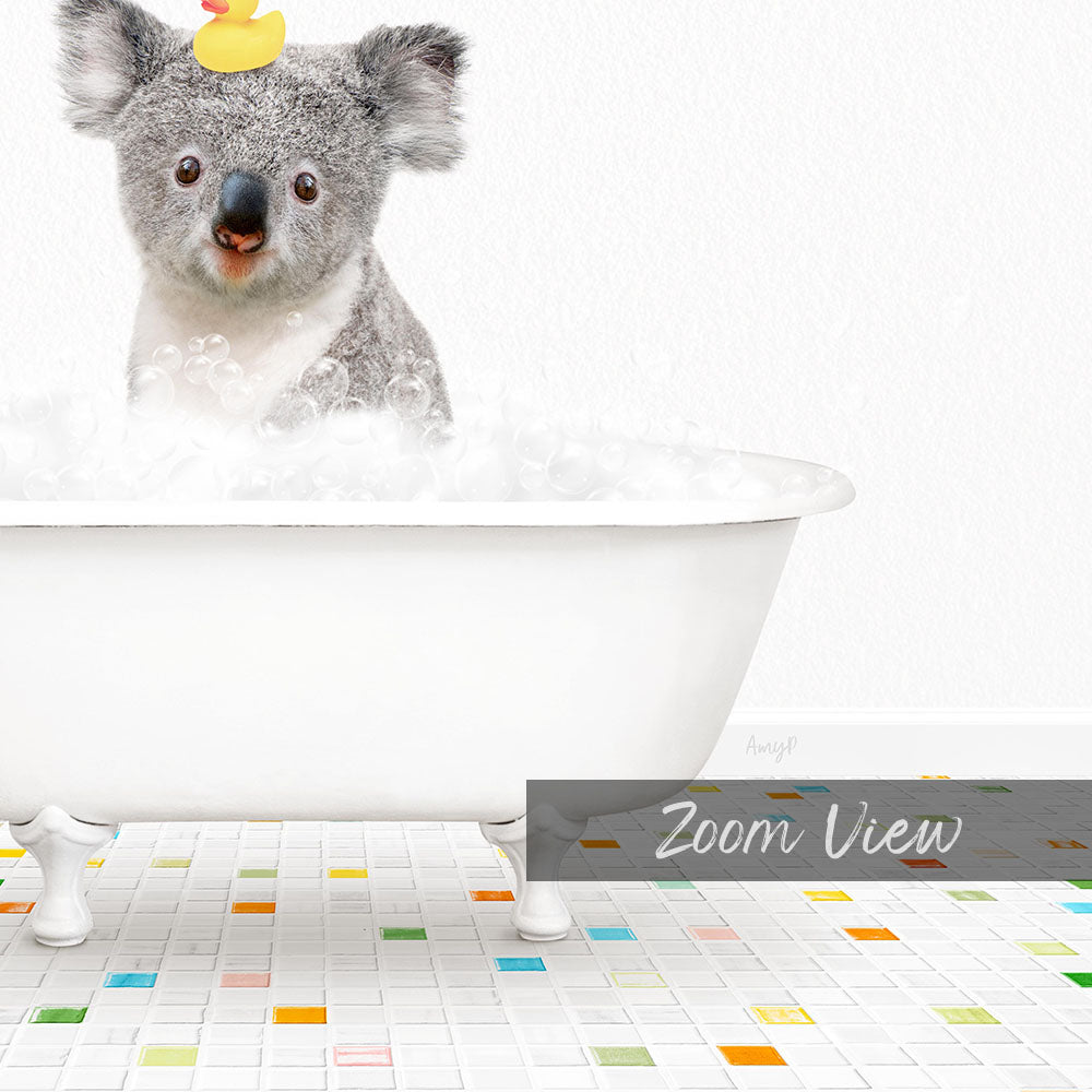 A koala bear sitting in a white bathtub filled with bubbles, with a rubber duck on its head.