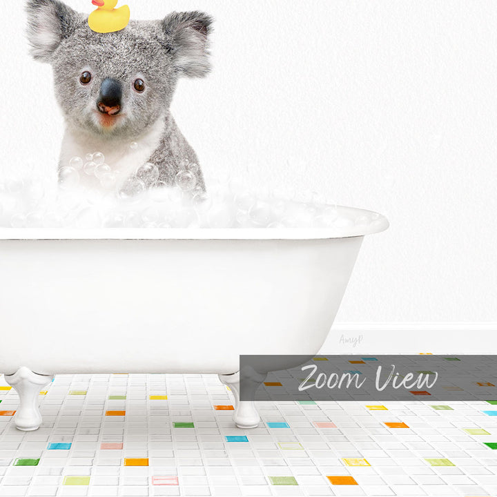 A koala bear sitting in a white bathtub filled with bubbles, with a rubber duck on its head.