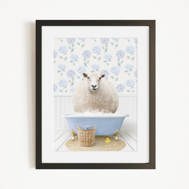 A fluffy white sheep sits in a blue bathtub filled with bubbles, surrounded by a wicker basket and yellow rubber ducks.