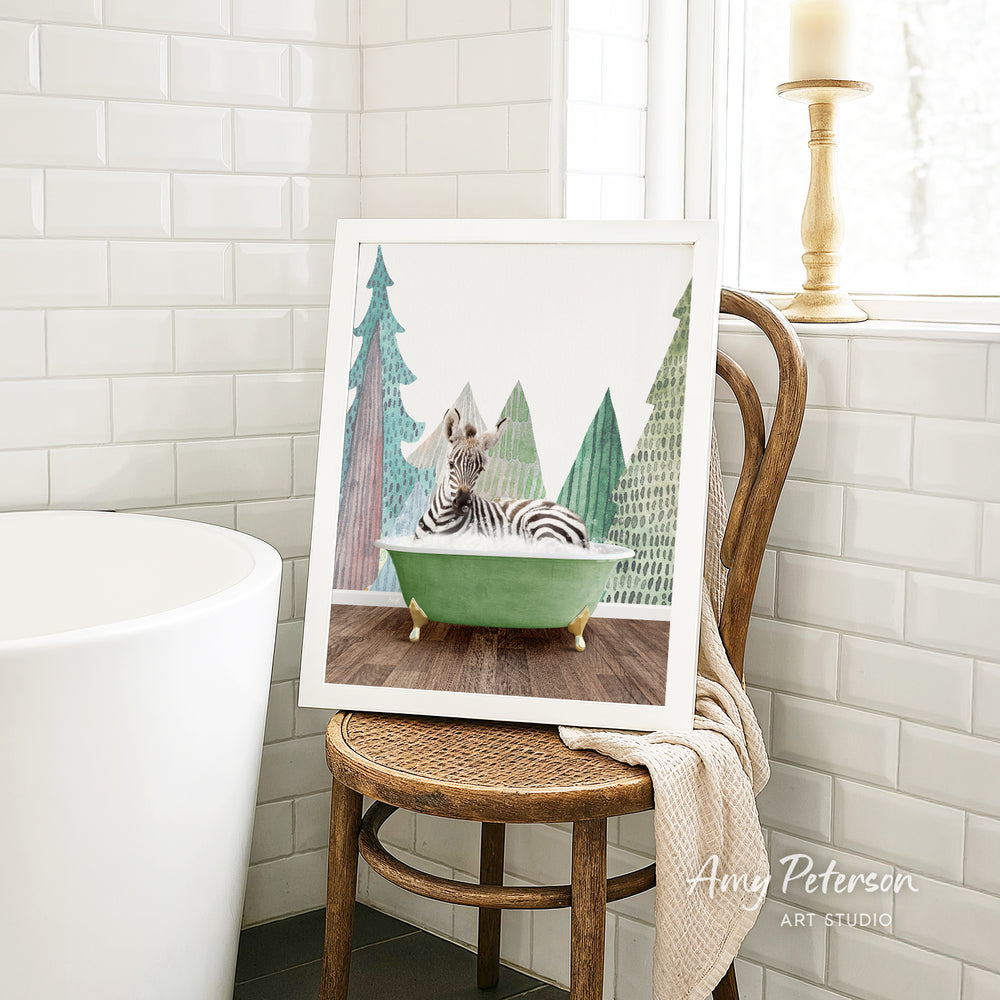 A framed painting of a zebra sitting in a green bathtub, surrounded by a snowy landscape with trees and a yellow lamp in the background.