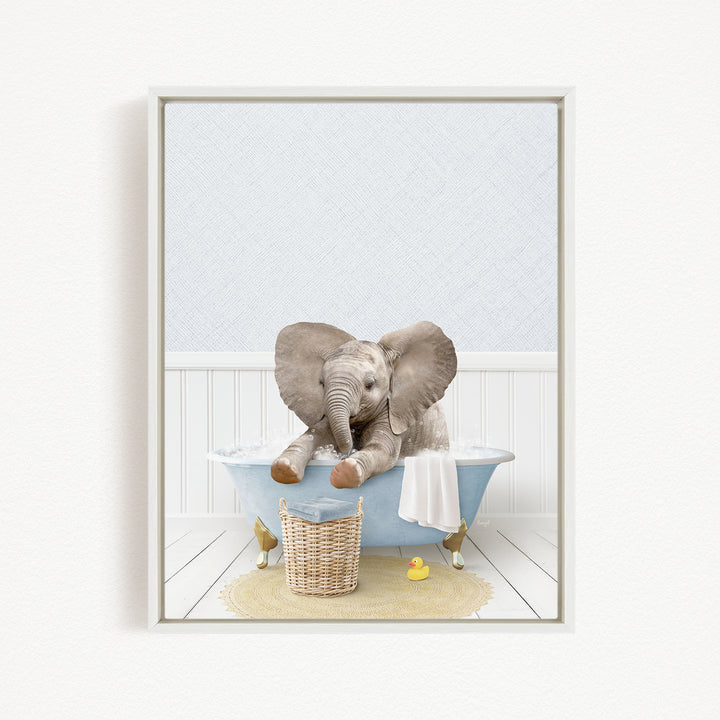 A baby elephant sitting in a bathtub filled with water, surrounded by a basket of toys and a yellow rubber duck.