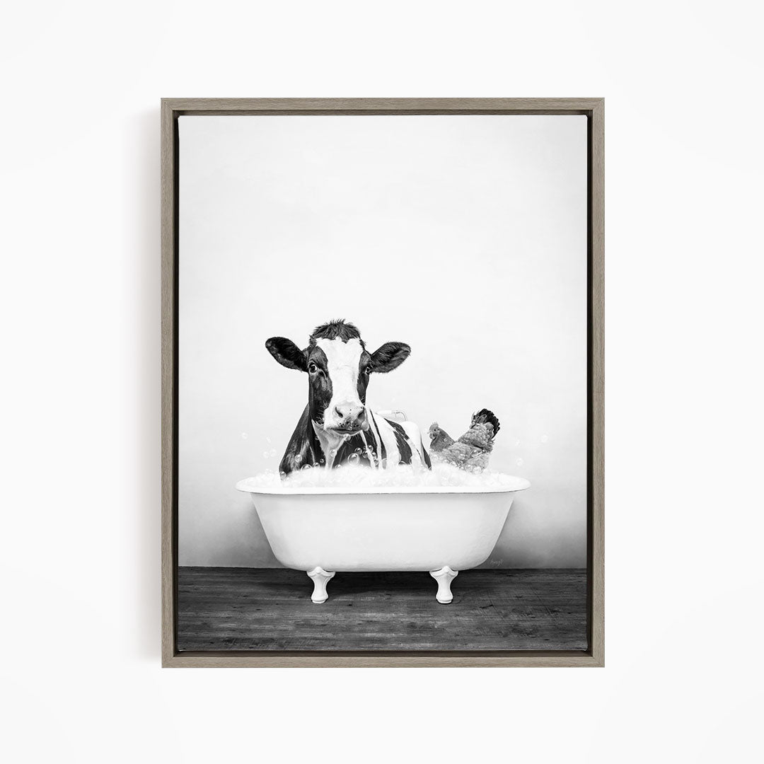 A black and white image of a cow sitting in a bathtub, with a chicken standing nearby.