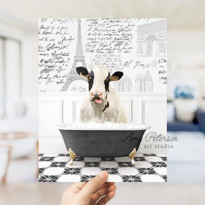 a person holding up a card with a picture of a cow in a bathtub