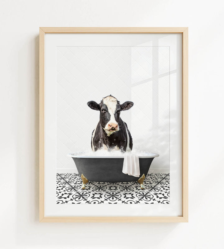 A black and white cow is sitting in a black bathtub filled with water, creating a whimsical and humorous scene.