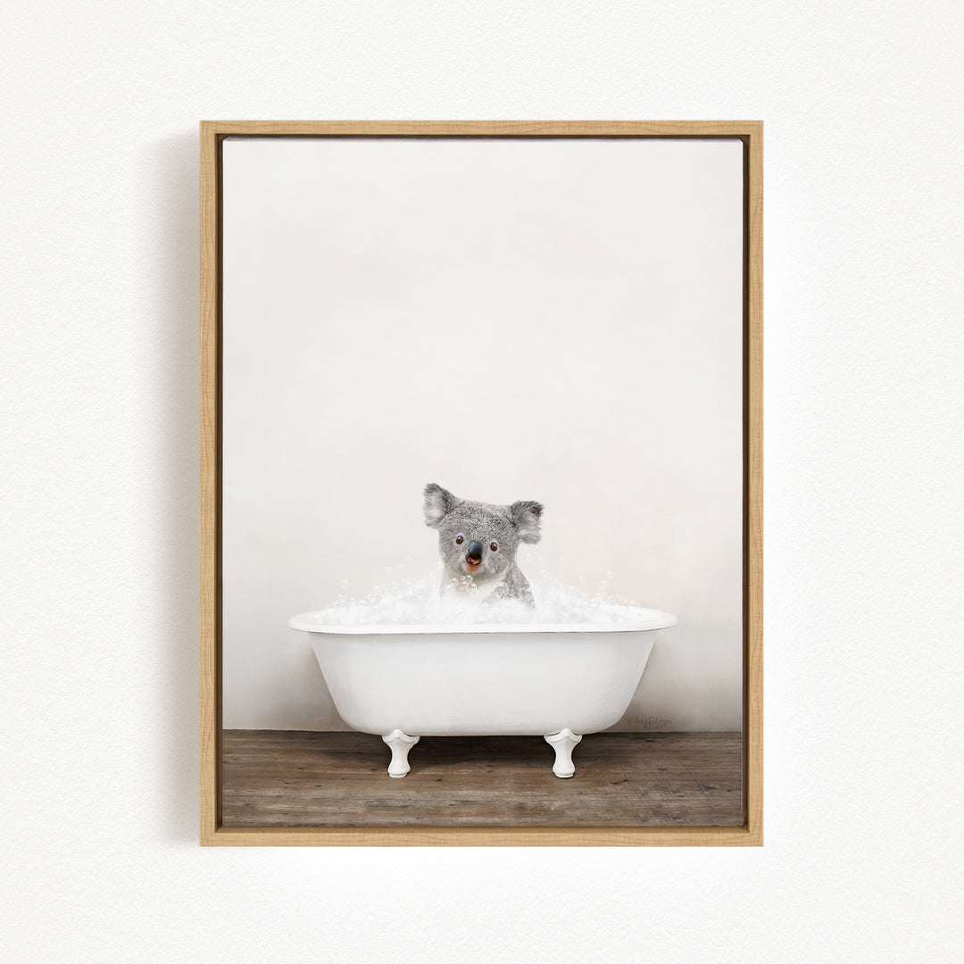 A koala bear sitting in a white bathtub filled with water, looking up at the camera.