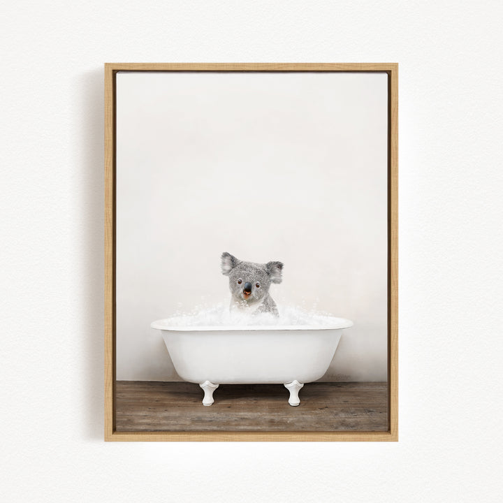 A koala bear sitting in a white bathtub filled with water, looking up at the camera.