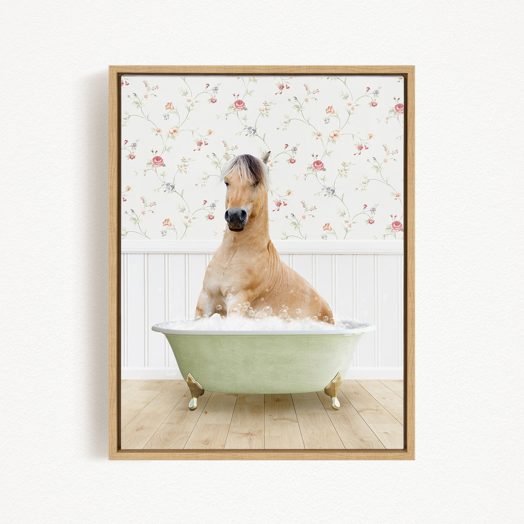 A light brown horse is sitting in a green bathtub filled with bubbles, with a floral wallpaper in the background.