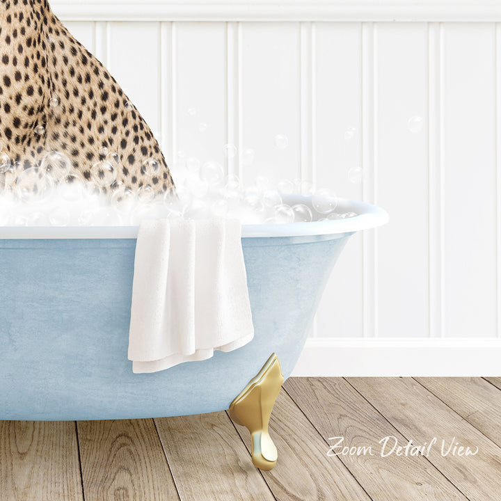 A leopard sitting in a blue bathtub filled with bubbles, with a towel and golden bathtub leg visible.