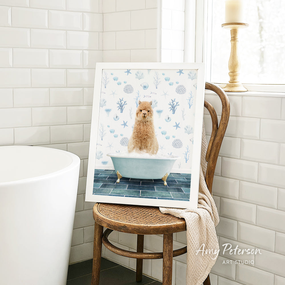 A framed image of a brown dog sitting in a blue bathtub, surrounded by blue and white floral patterns, is displayed on a wooden chair in a bathroom setting.