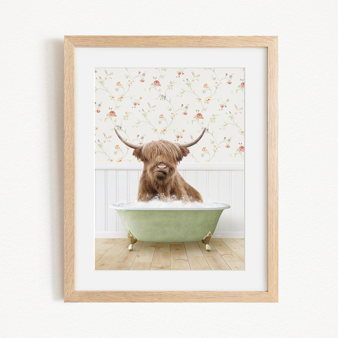 A brown cow with long horns is sitting in a green bathtub, surrounded by a floral patterned wall.
