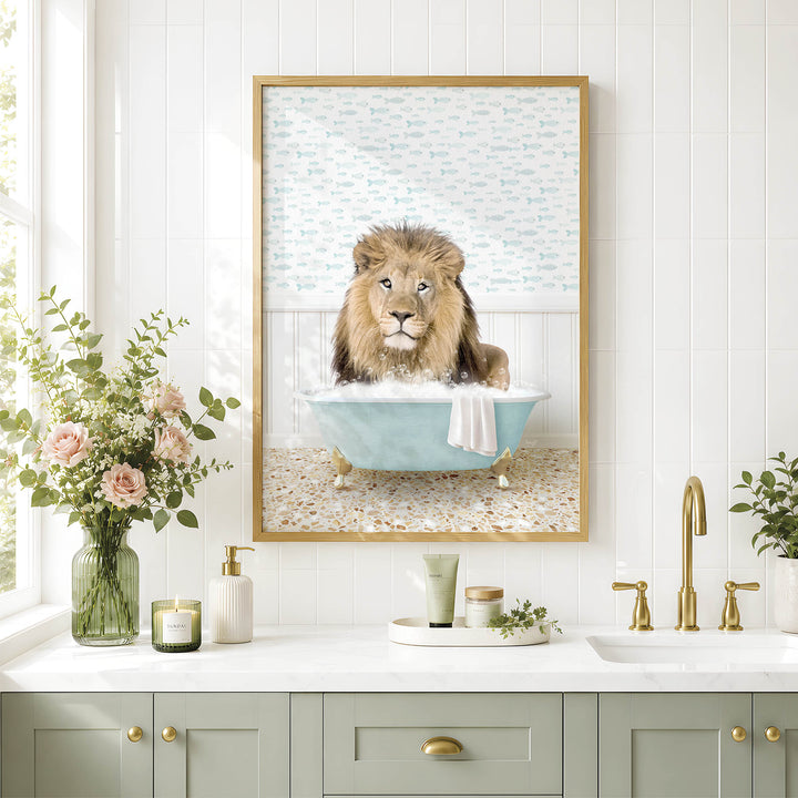A framed image of a lion sitting in a bathtub, surrounded by flowers and a green vase, is displayed on a white tiled wall above a bathroom sink.