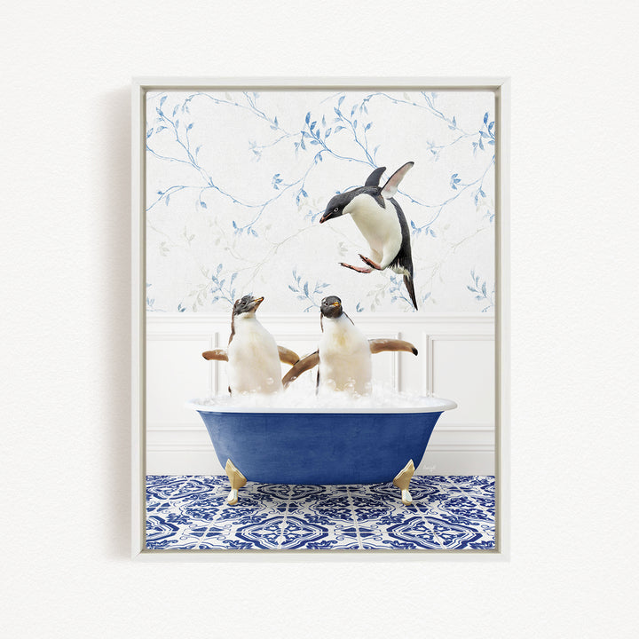 A framed image depicting three penguins sitting in a blue bathtub, with one penguin flying towards the others.