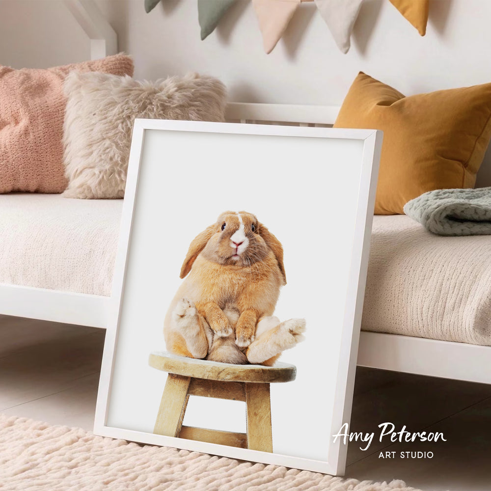 A framed image of a rabbit sitting on a wooden stool, with a cozy and inviting atmosphere in the background.