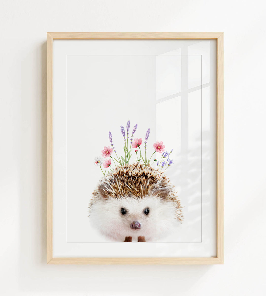 A framed print of a cute hedgehog with flowers on its head.