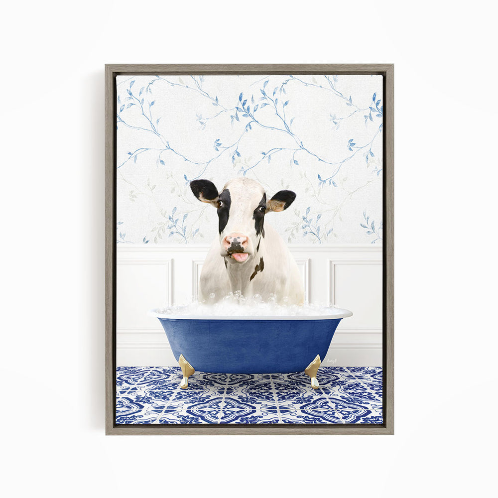 A black and white cow is sitting in a blue bathtub filled with water, with a floral patterned wall behind it.