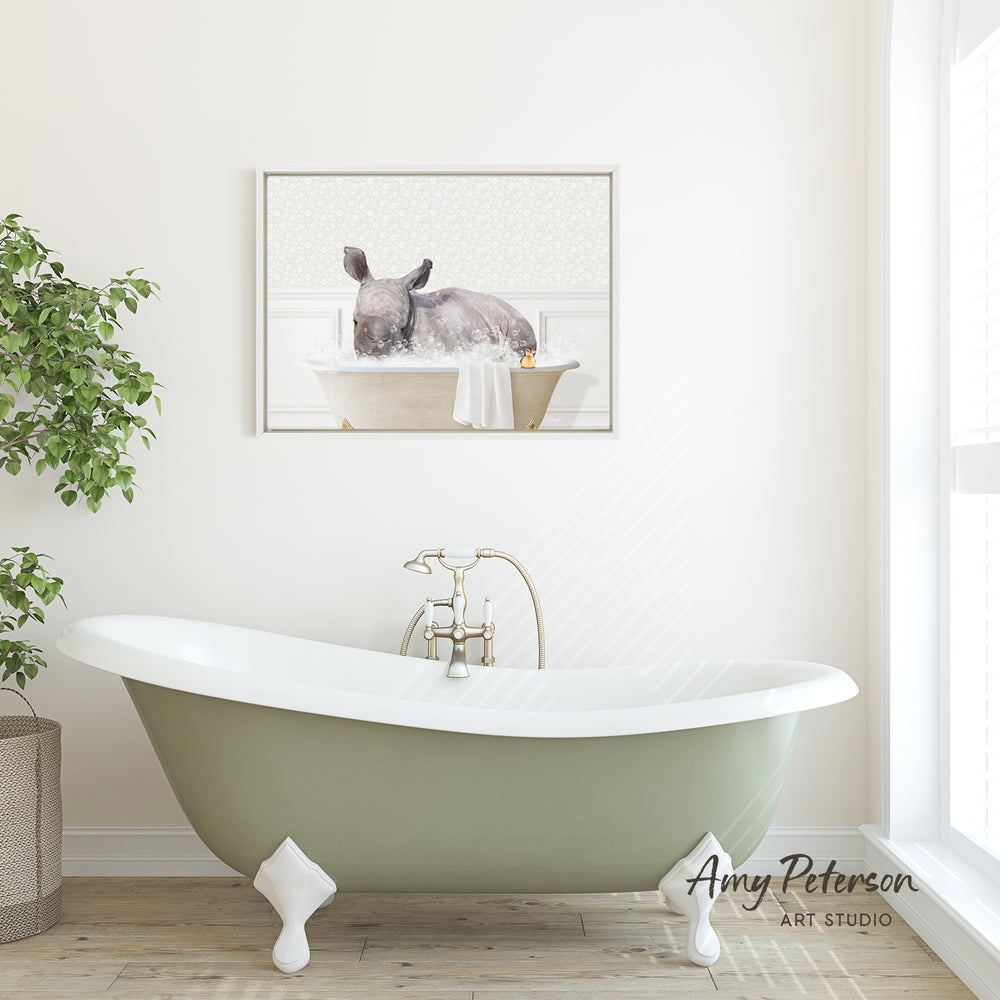 A green clawfoot bathtub with a white interior is featured in a bright, white bathroom with a framed image of a rhinoceros in a bathtub hanging on the wall above it.
