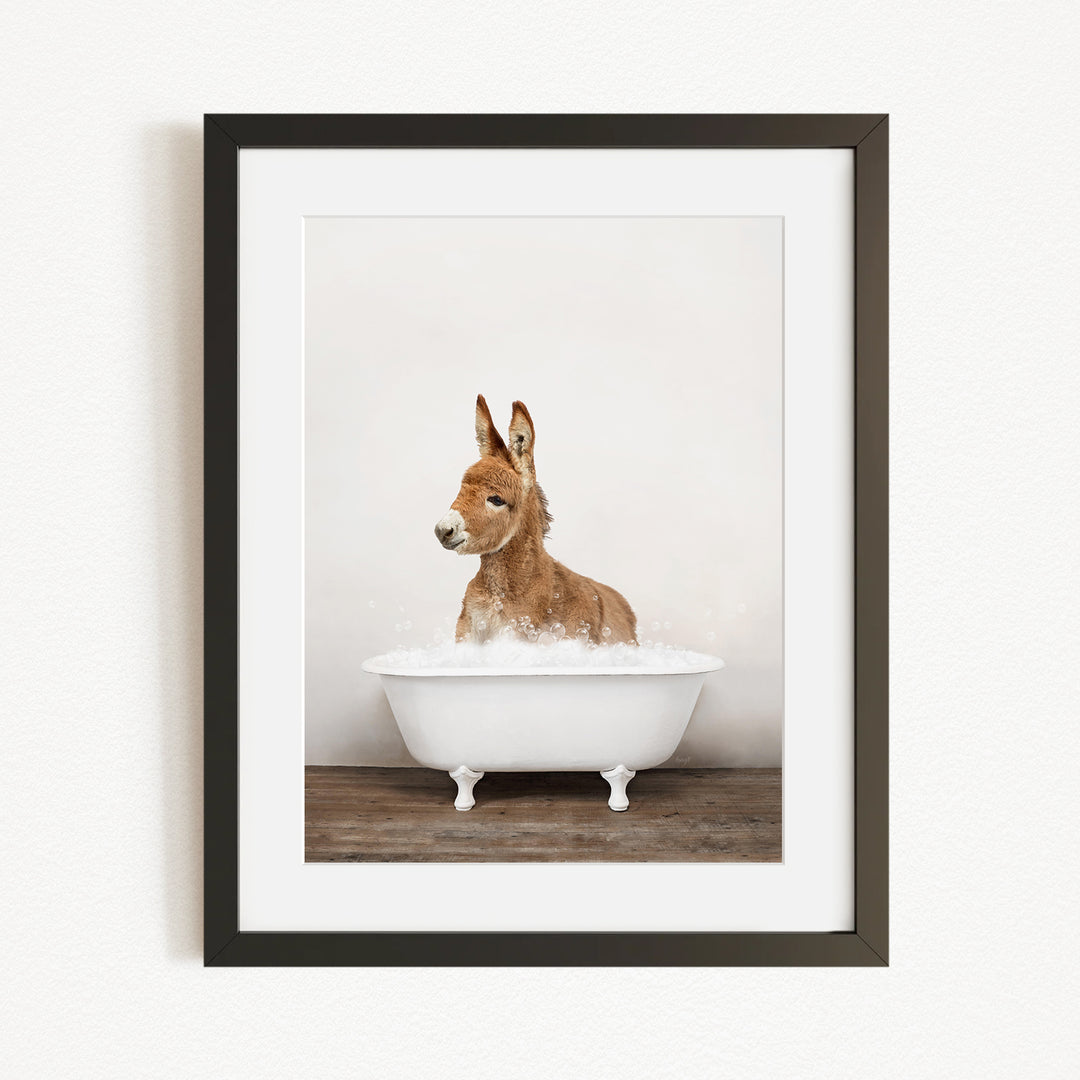 A donkey is sitting in a white bathtub filled with water, creating a playful and whimsical scene.