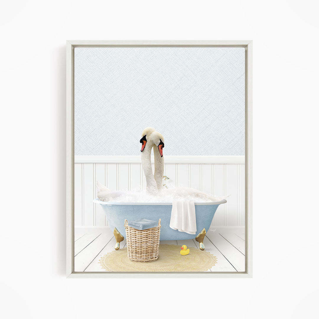 A white swan is sitting in a blue bathtub filled with bubbles, with a yellow rubber duck nearby.