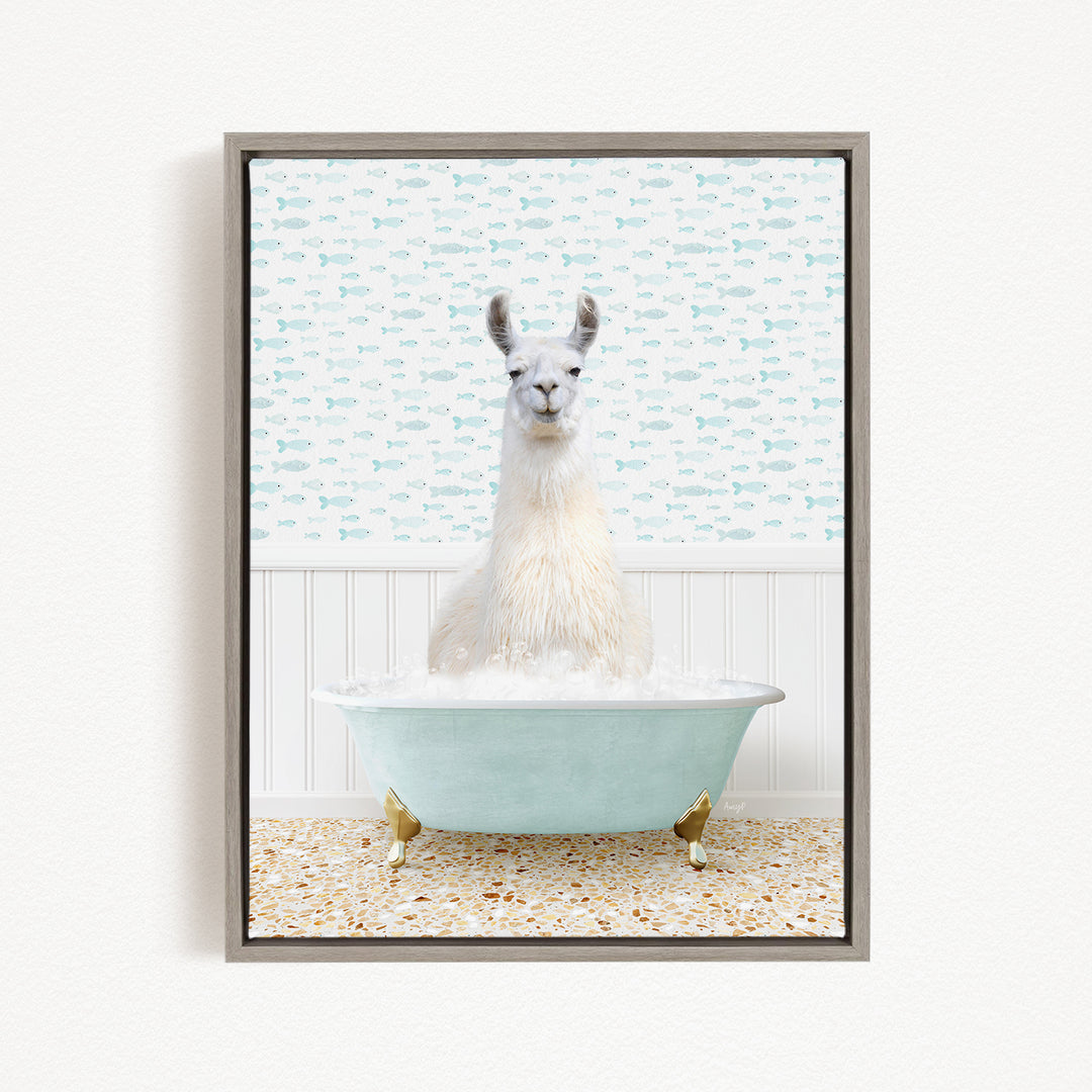 A white llama sitting in a light blue bathtub filled with bubbles, surrounded by a pattern of small fish on the wall behind it.