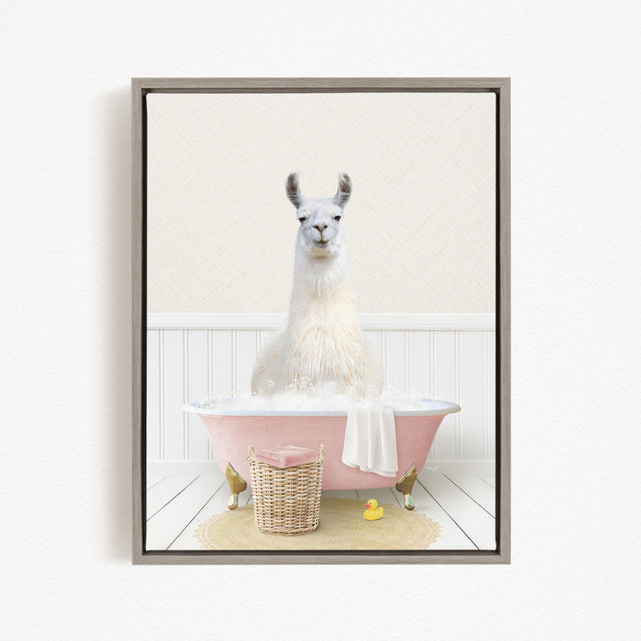 A white llama sitting in a pink bathtub filled with water, surrounded by a yellow rubber duck and a wicker basket.