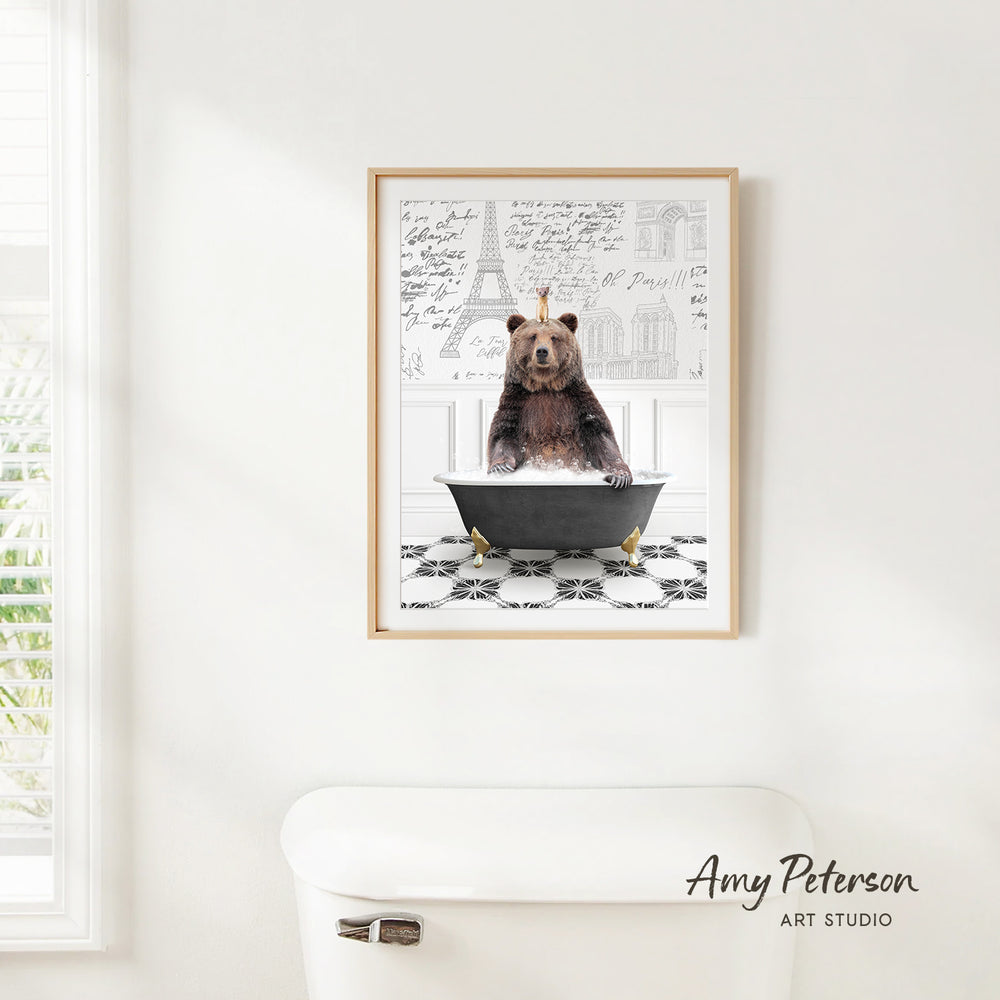 A framed image of a bear sitting in a bathtub, with a tiled floor and a drawing of the Eiffel Tower in the background.