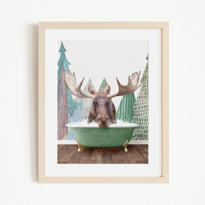 A moose with large antlers is sitting in a green bathtub, surrounded by a forest scene with trees and a snowy landscape.