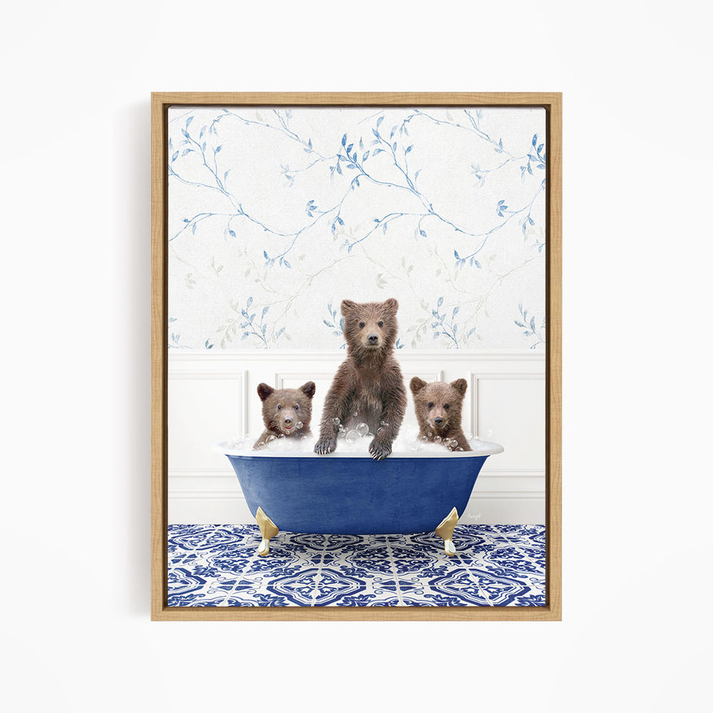 A framed image depicting three bears sitting in a blue bathtub, with a patterned tile floor and a floral wallpaper in the background.