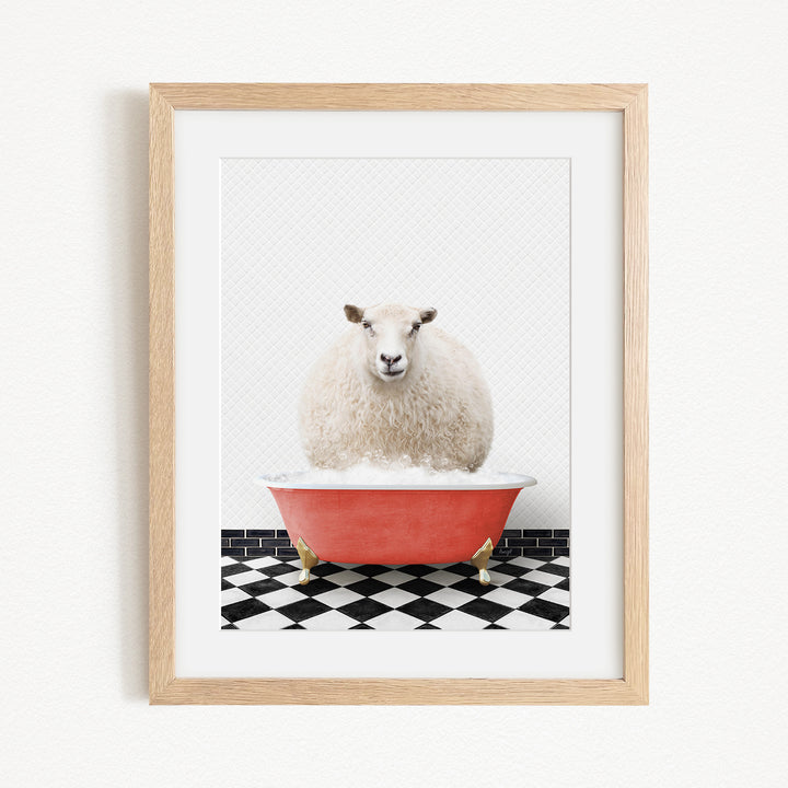 A fluffy white sheep sits in a red bathtub on a black and white checkered floor, with a wooden frame surrounding the image.