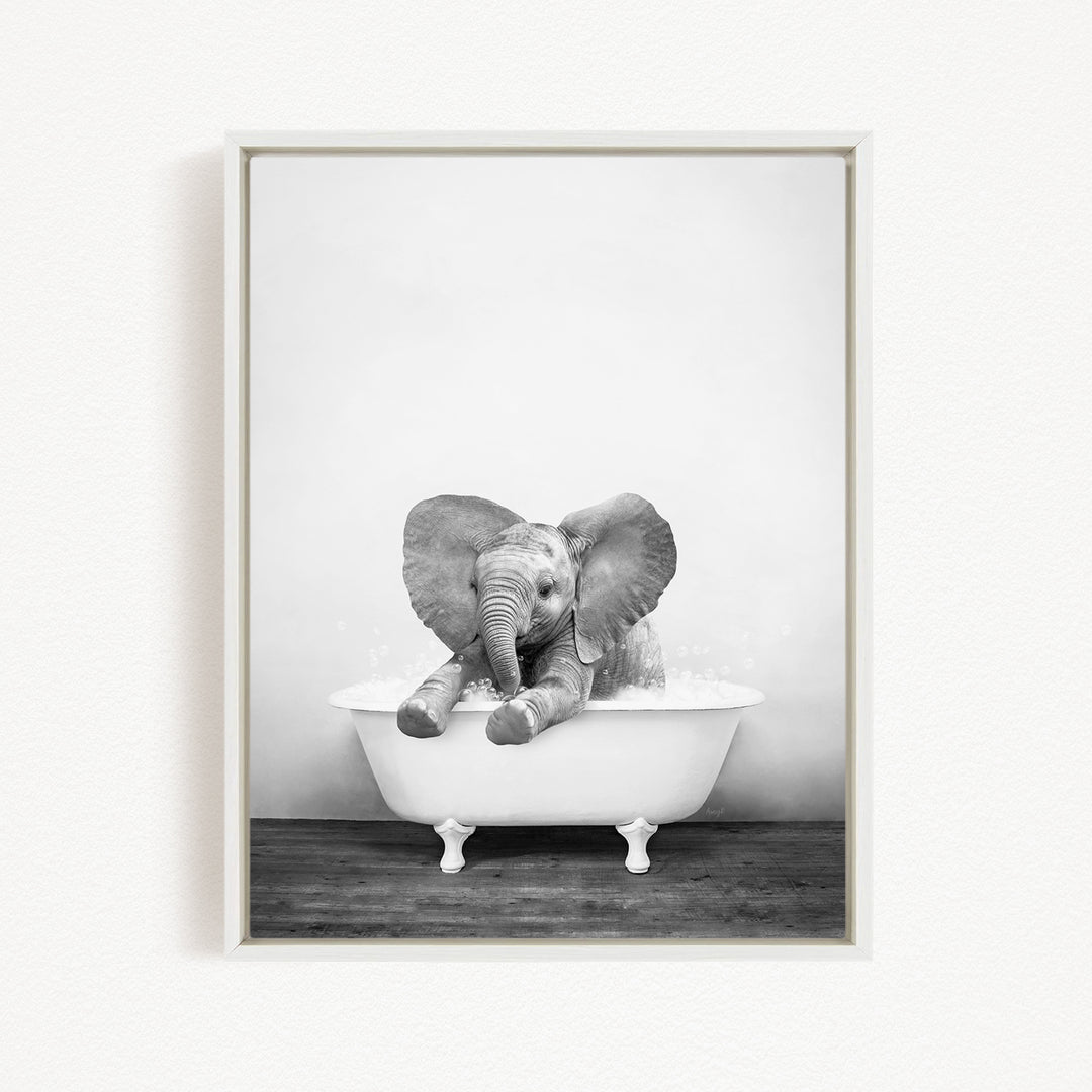 A baby elephant sitting in a bathtub filled with water, appearing to enjoy the bath.