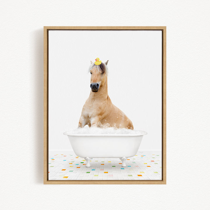 A horse is sitting in a white bathtub filled with bubbles, with a rubber duck perched on its head.