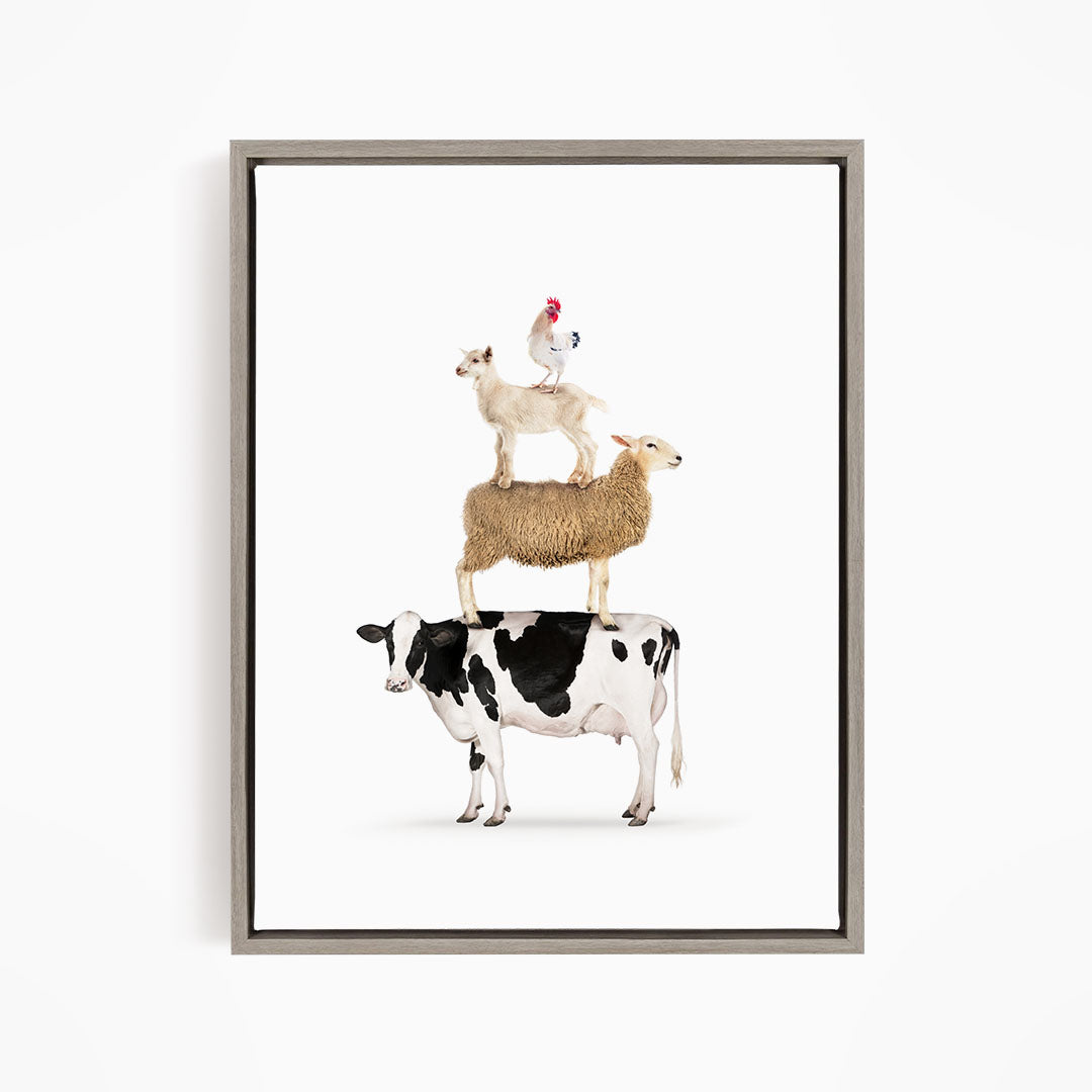 A framed image depicting a cow, sheep, and chicken stacked on top of each other.