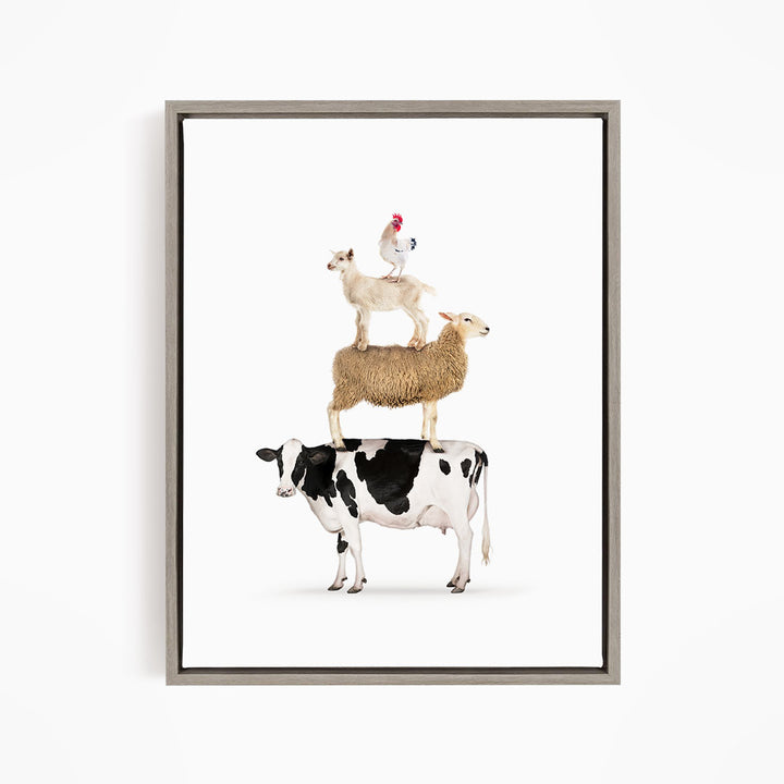 A framed image depicting a cow, sheep, and chicken stacked on top of each other.