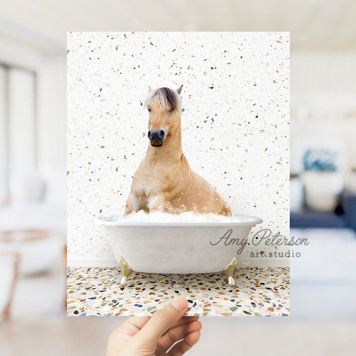 a hand holding a card with a horse in a bathtub