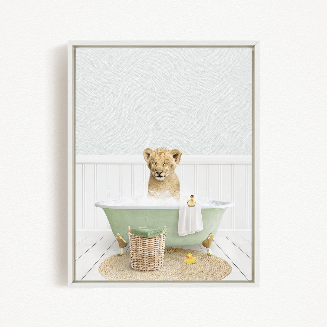 A young lion cub sitting in a green bathtub filled with bubbles, surrounded by a basket of toys and a yellow rubber duck.