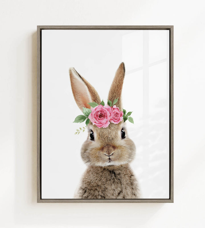 A cute bunny rabbit wearing a floral crown of pink roses and greenery.
