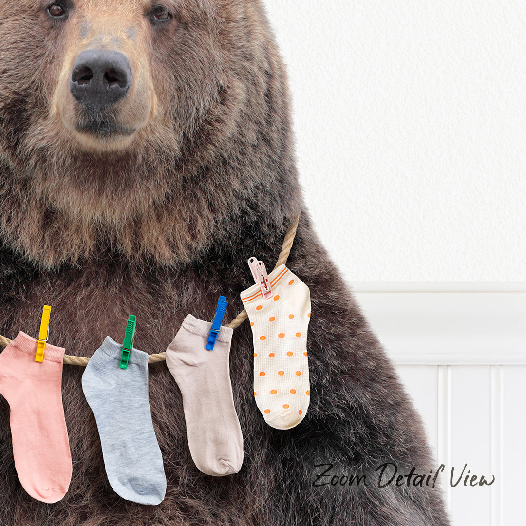 A large brown bear wearing a clothesline with colorful socks hanging on it.