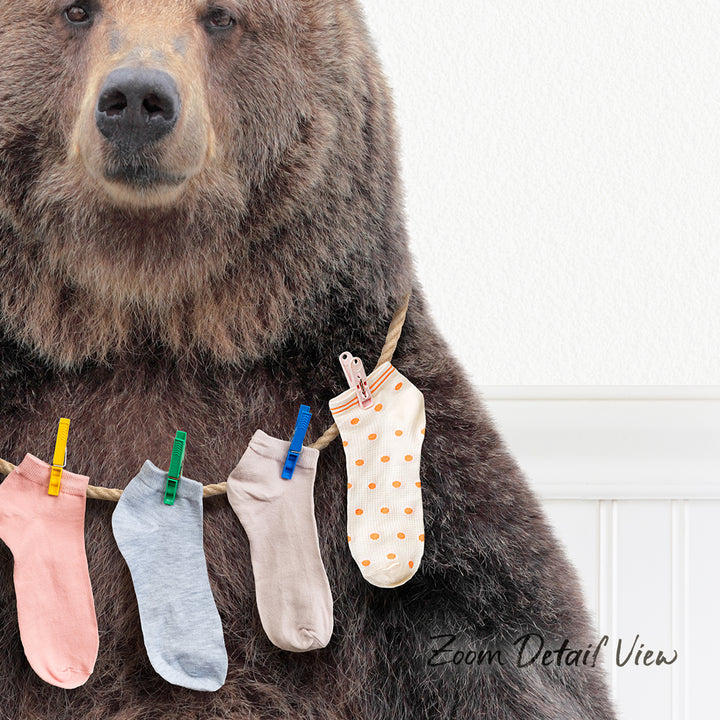 A large brown bear wearing a clothesline with colorful socks hanging on it.