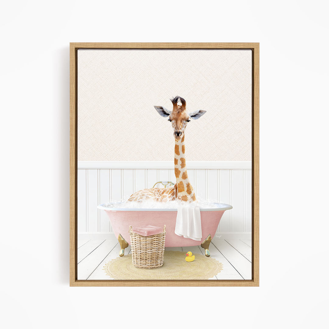 A giraffe is sitting in a pink bathtub filled with bubbles, surrounded by a yellow rubber duck and a wicker basket.