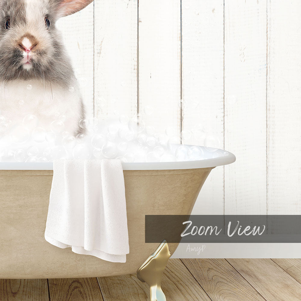 A fluffy white rabbit sitting in a bathtub filled with bubbles, with a towel draped over the side and a "Zoom View" label below the image.