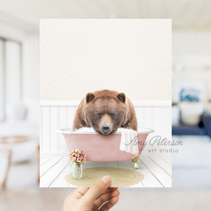 a person holding up a card with a bear in a bathtub