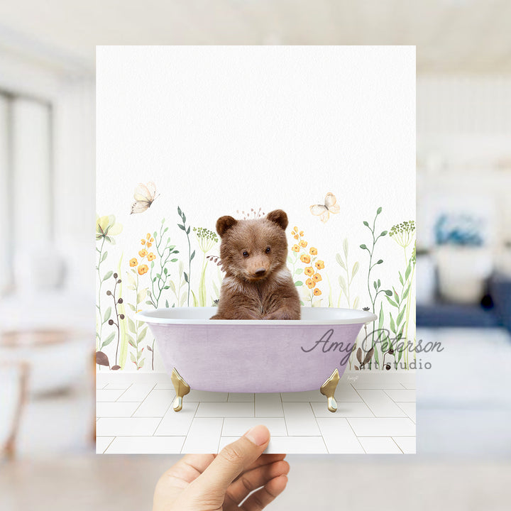 a person holding a card with a picture of a teddy bear in a bathtub