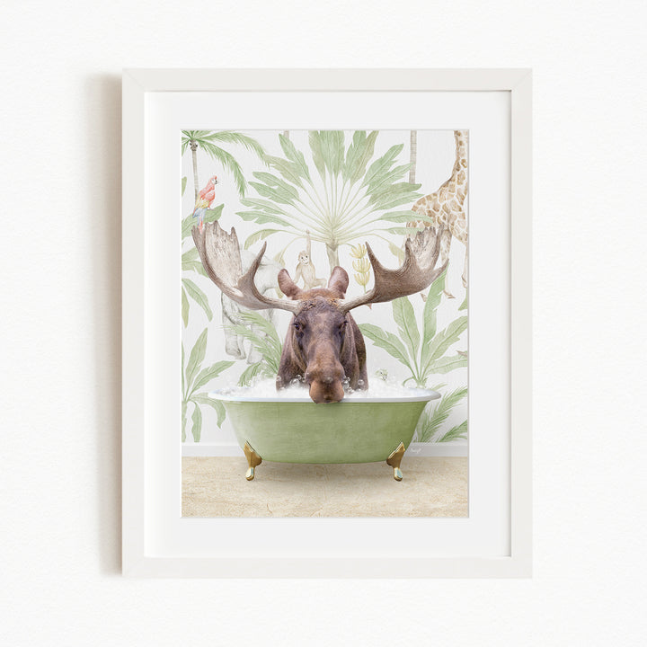 A moose with large antlers is sitting in a green bathtub, surrounded by a tropical wallpaper with palm leaves and a giraffe.
