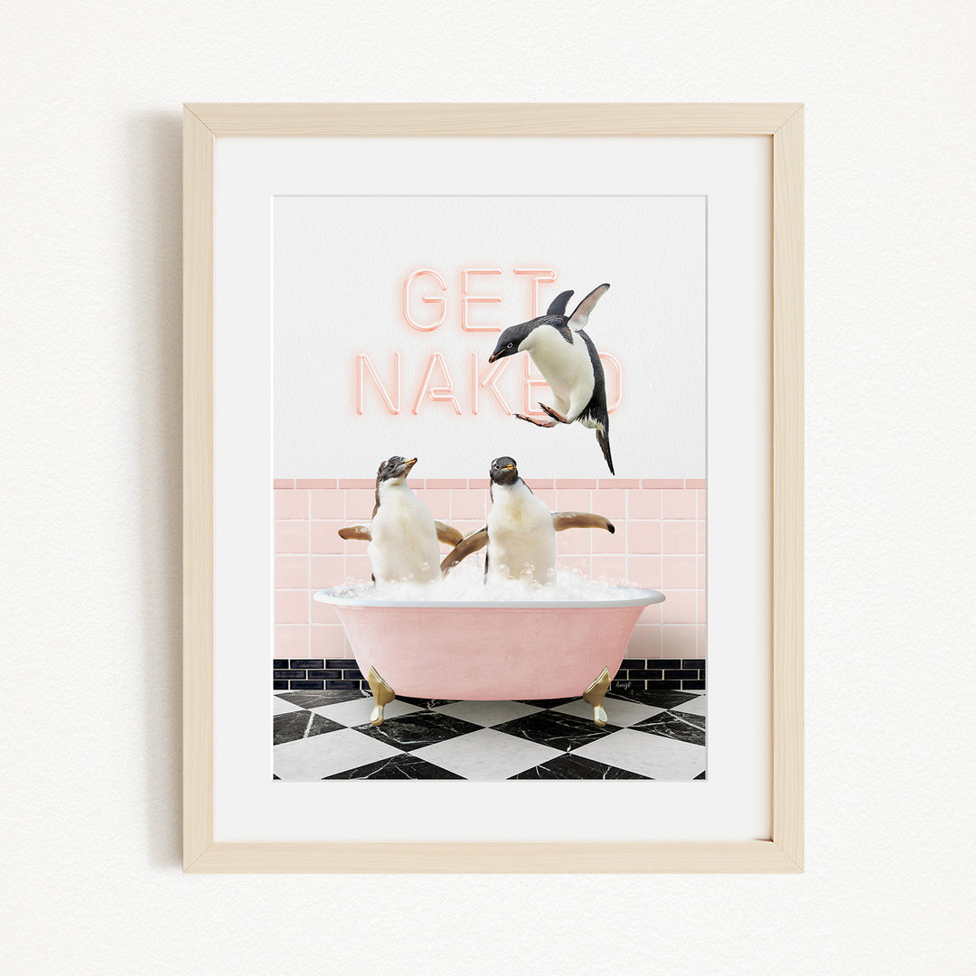 A framed image depicting two penguins sitting in a pink bathtub, with one penguin jumping out of the tub and the other penguin sitting in the tub. The background features a pink wall with the text "GET NAKED" written on it.