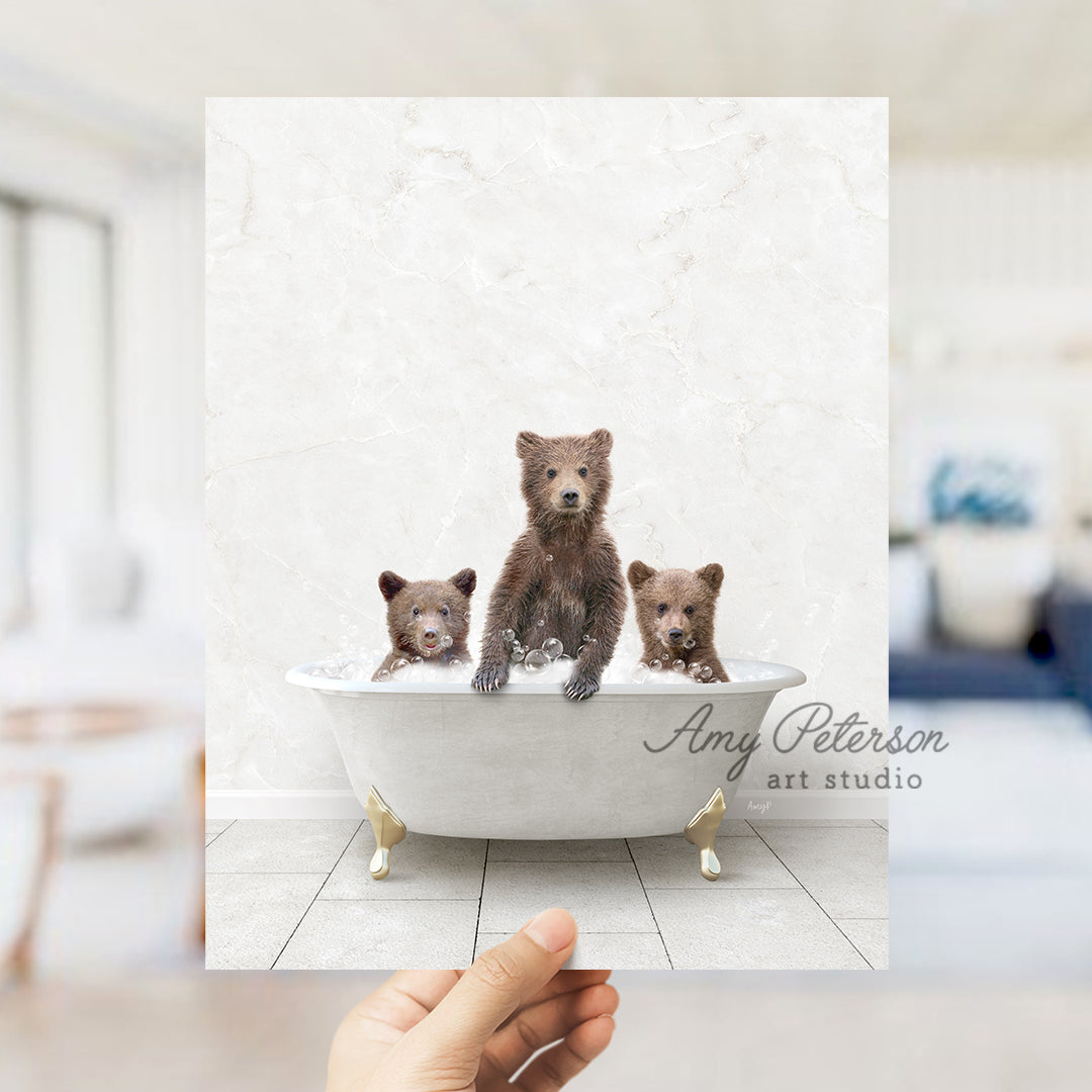 a hand holding a card with three bears in a bathtub