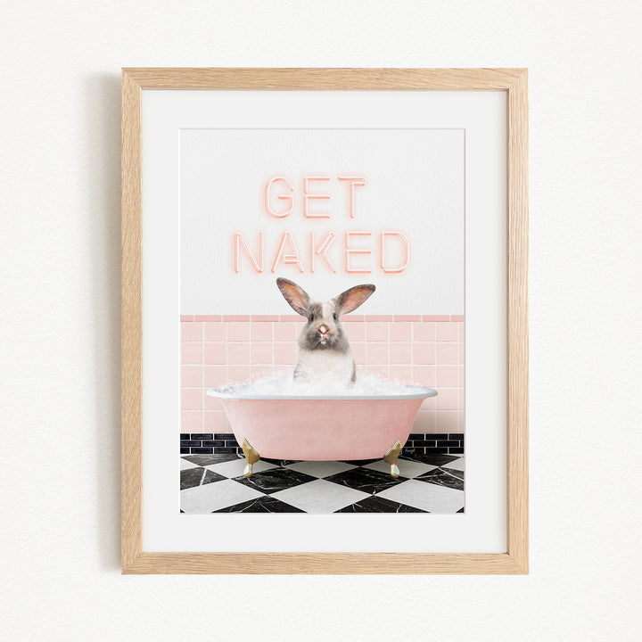 A framed image depicting a rabbit sitting in a pink bathtub filled with bubbles, with the text "GET NAKED" displayed above it.