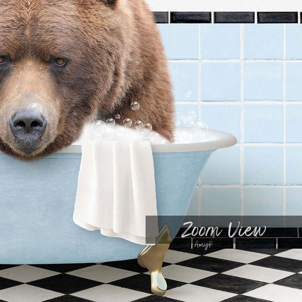 A large brown bear is sitting in a blue bathtub filled with bubbles, with a towel draped over the side of the tub.