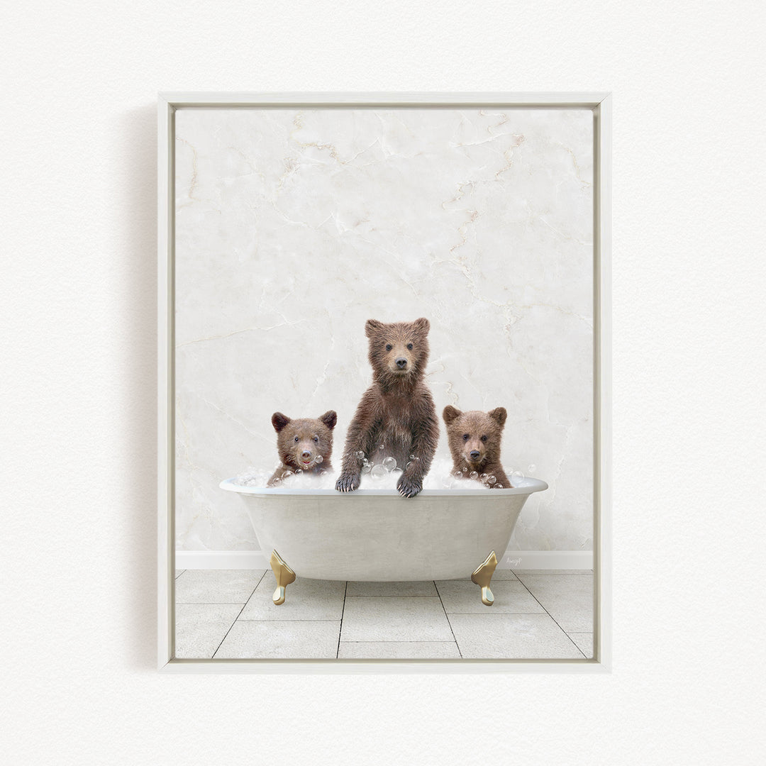 A framed image depicting three brown bears sitting in a white bathtub, with one bear sitting at the top and the other two sitting at the bottom.