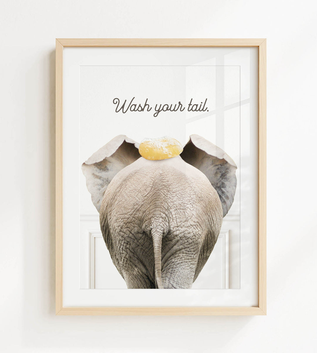 an elephant with a yellow object on its head, accompanied by the text "Wash your tail."